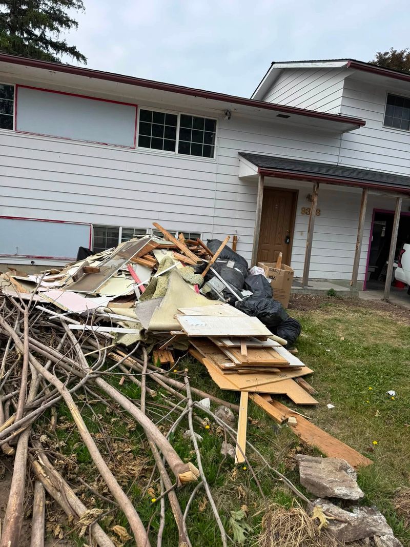 Pile of drywall, lumber and renovation debris cleared from the front of a house