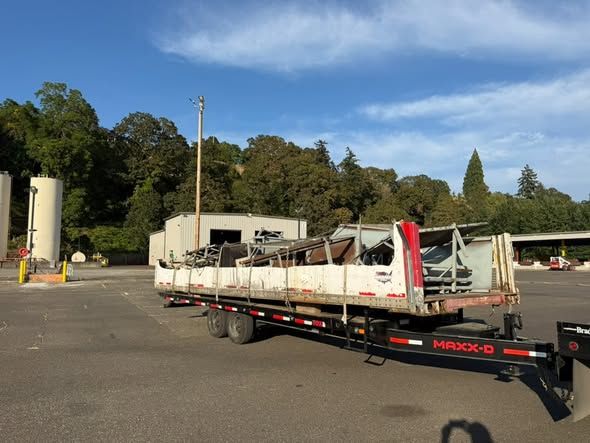 Demolished structure loaded on a flatbed trailer at the disposal yard